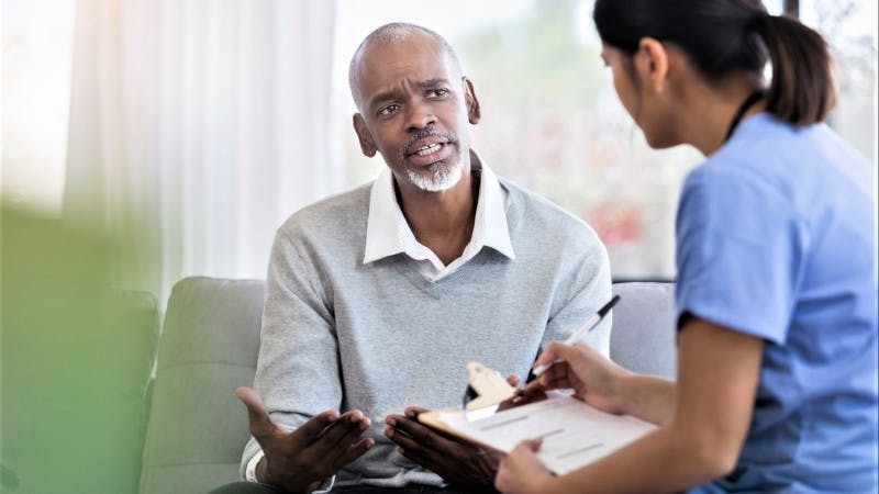 Male patient talking with healthcare worker 